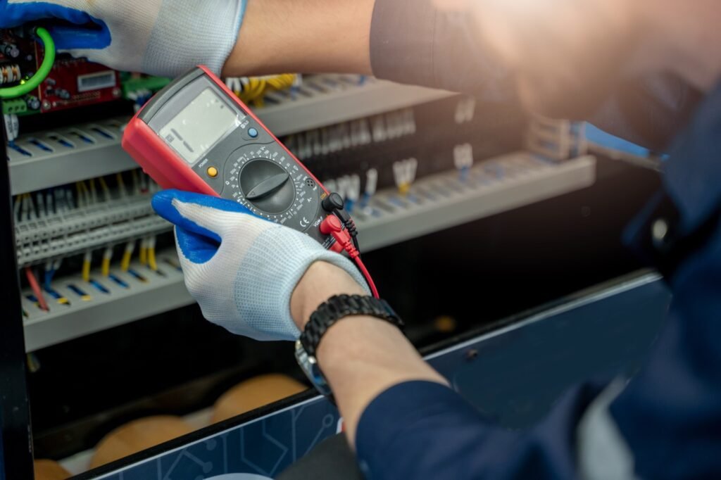 Elektrikas matuoja įtampą elektros skyde